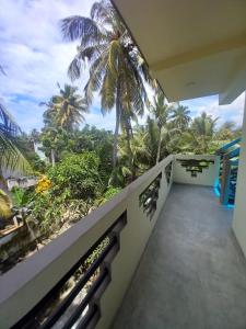 a balcony with a view of the palm trees at cric villa in Galle