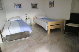 Orselina的住宿－Casa via Patocchi 41，一间卧室配有两张床和椅子