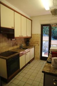 Il comprend une cuisine équipée d'un évier et d'une cuisinière. four supérieur dans l'établissement Casa via Patocchi 41, à Orselina
