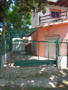 a green gate in front of a building at Salón Amplio Céntrico Habitación Privada 4 personas in Cosquín