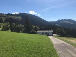 a house in a field next to a road at Soldanella in Appenzell