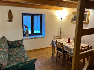 a living room with a table and a couch at Les Chambrettes in Champoluc