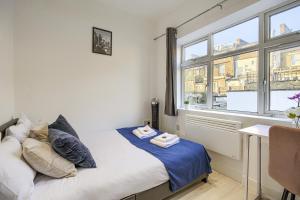 a small bedroom with a bed and a window at The Finsbury Deluxe Apartments in London