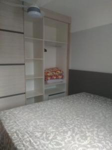 a bedroom with a bed and a closet with shelves at Condomínio cesars park flats in Caldas Novas