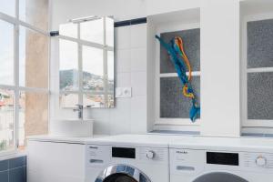 a white laundry room with a washing machine at Regina's Banyuls - Exklusiv lägenhet med havsvy in Banyuls-sur-Mer