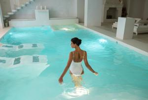 Una donna sta in piedi in una piscina di Baglioni Masseria Muzza a Otranto