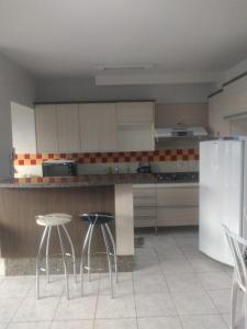 a kitchen with a counter with stools and a refrigerator at Condomínio cesars park flats in Caldas Novas