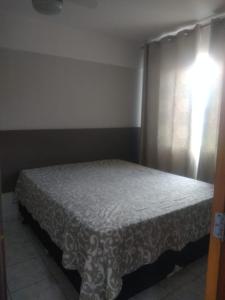 a bedroom with a white bed with a window at Condomínio cesars park flats in Caldas Novas