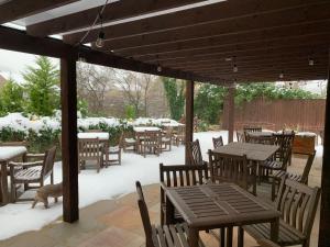 un patio con mesas y sillas en la nieve en The Tavern, en Matlock