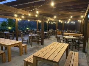un restaurante con mesas de madera, sillas y luces en The Tavern, en Matlock