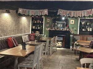 um restaurante com mesas e cadeiras e uma lareira em The Tavern em Matlock