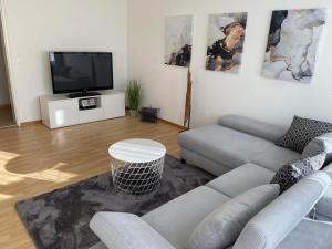 a living room with a couch and a flat screen tv at Sonnendurchflutete gemütliche Ferienwohnung in Wildhaus