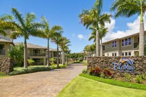a driveway in front of a building with palm trees at 3 Bedroom 3 Bathroom Condo with Ocean View - Alekona Kauai in Koloa