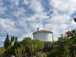 a lighthouse on a hill with trees and a cloudy sky at Ha Mar ao Luar in Setúbal