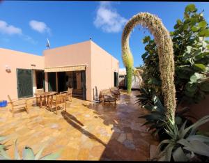 un patio con sedie e un edificio con arco di Casa Volcan a Corralejo