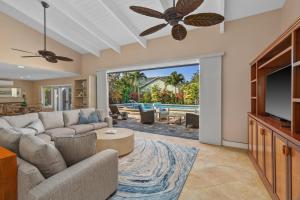 a living room with a couch and a tv at Poipu Kai 3 Bedroom with Pool and Spa- Alekona Kauai in Koloa