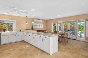 a kitchen with white cabinets and a dining room at Poipu Kai 3 Bedroom with Pool and Spa- Alekona Kauai in Koloa