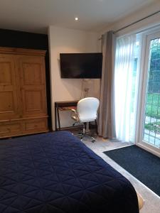 a bedroom with a bed and a desk and a window at Garden Room in Bromsgrove