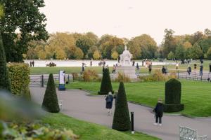 a group of people walking around a park with a fountain at Sonder Kensington Gardens in London