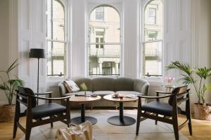 ロンドンにあるSonder Kensington Gardensのリビングルーム(ソファ、テーブル2台、椅子付)