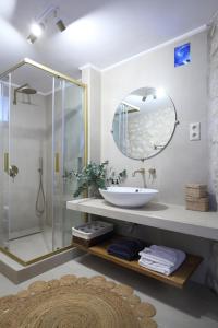 uma casa de banho com um lavatório e um chuveiro com um espelho. em Georgia Villas em Drymon