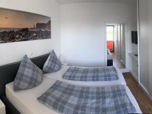 1 dormitorio con 2 camas y almohadas de color azul en Tor zum Meer, en Helgoland