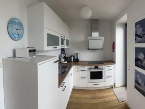 a kitchen with white cabinets and a counter top at Tor zum Meer in Helgoland