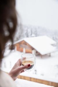 a person holding a glass of wine at La Ferme du Golf in Megève