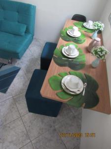 une table de salle à manger avec des assiettes et des plats dessus dans l'établissement Apartamento Aconchegante, à Praia Grande