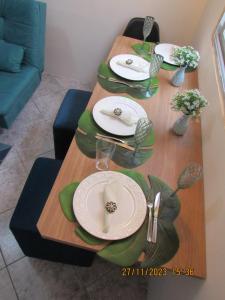 une table avec des assiettes et des serviettes en haut dans l'établissement Apartamento Aconchegante, à Praia Grande