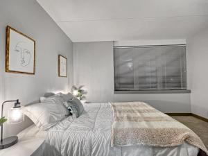 a white bedroom with a bed and a window at Downtown 1br Gem Steps Away From Wells Fargo in Des Moines