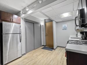 a kitchen with a stainless steel refrigerator and a door at Downtown 1br Gem Steps Away From Wells Fargo in Des Moines +5 photos