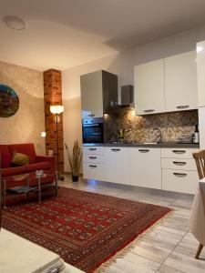uma cozinha com armários brancos e um sofá vermelho em Apartman "Almond house 2" em Pula