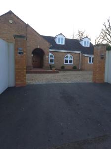 a brick house with a garage and a driveway at Garden Room in Bromsgrove