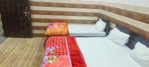 Cama en habitación con cabecero de madera en K.D. Dham near Prem mandir, en Vrindāvan