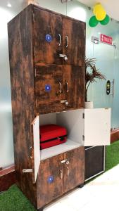 a large wooden cabinet with a red seat inside at Laxmi Dormitory in Vrindāvan