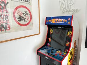 Cool 2 Bed Hornchurch House, Arcade Games, Free Parking في Hornchurch: آلة ألعاب فيديو أروقة بجوار جدار