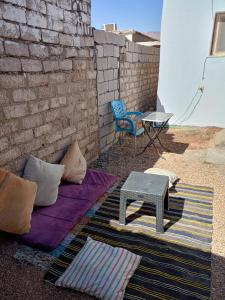 um pátio com uma mesa, uma cadeira e um tapete em Studio with a spacious garden in Al-Assla em Dahab