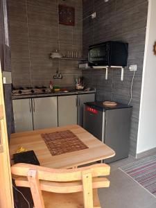 una cucina con tavolo in legno e forno a microonde di Studio with a spacious garden in Al-Assla a Dahab
