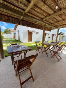 a group of tables and chairs under a pavilion at Vila Mandakaru in São Miguel do Gostoso