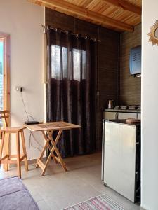a room with a table and a kitchen with a counter at Studio with a spacious garden in Al-Assla in Dahab
