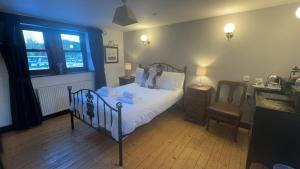 a bedroom with a bed and a desk and a chair at The White Bull in Gisburn