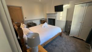 a bedroom with a bed with a fireplace and a television at The White Bull in Gisburn
