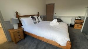 a bedroom with a large bed with white sheets and pillows at The White Bull in Gisburn