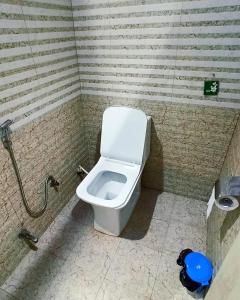 a bathroom with a white toilet in a stall at Laxmi Dormitory in Vrindāvan