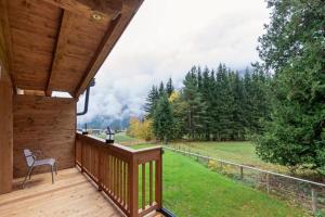 a wooden deck with a view of a forest at Wasserfall Lodge Krimml in Krimml