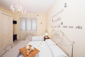 een slaapkamer met 2 bedden en een kroonluchter bij LE QUATTRO STAGIONI in Brindisi