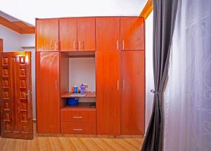 a large wooden cabinet with a sink in a room at Kibibi Lake view furnished suites in Wakiso