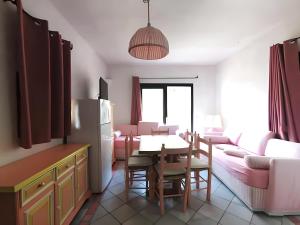 a kitchen and living room with a table and a refrigerator at Seaside Apartment Baja Sardinia - 6pl August - 250 m from smeraldo beach in Baja Sardinia +43 photos