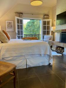 a bedroom with a large bed and a large window at Hotel L'Auberge in Punta del Este